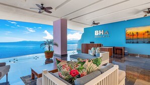 Eine geräumige Lounge mit Meerblick, eine Rezeption und eine blaue Wand mit dem BH Residences Logo.