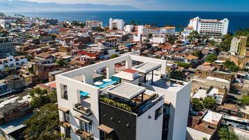 Un edificio moderno con piscina en la azotea y vistas al mar.