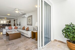 Ein modernes Wohnzimmer mit einer Couch, einem Couchtisch und einer Topfpflanze.