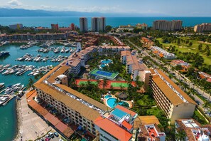A coastal resort with multiple buildings, a marina, and a swimming pool. - Marina Condo Near Golf Course, Beach, & Dining With Pool & Tennis Courts (Puerto Vallarta)