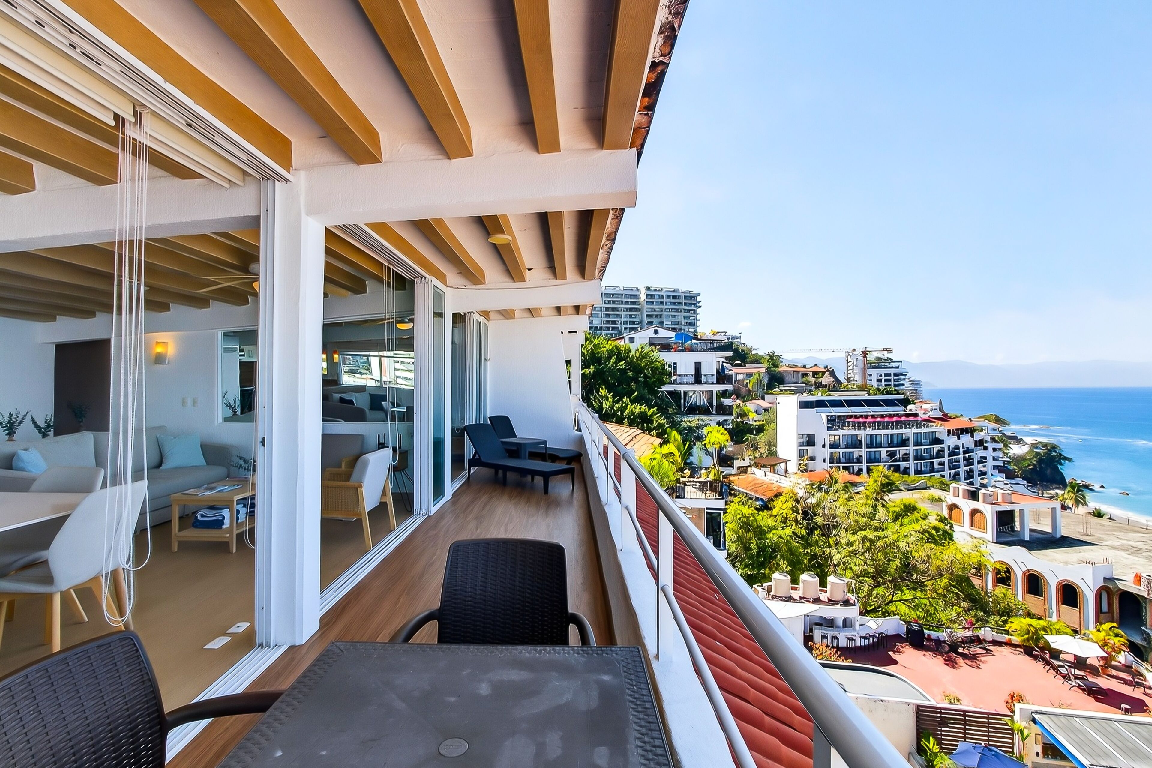 A balcony with a view of the beach and cityscape.