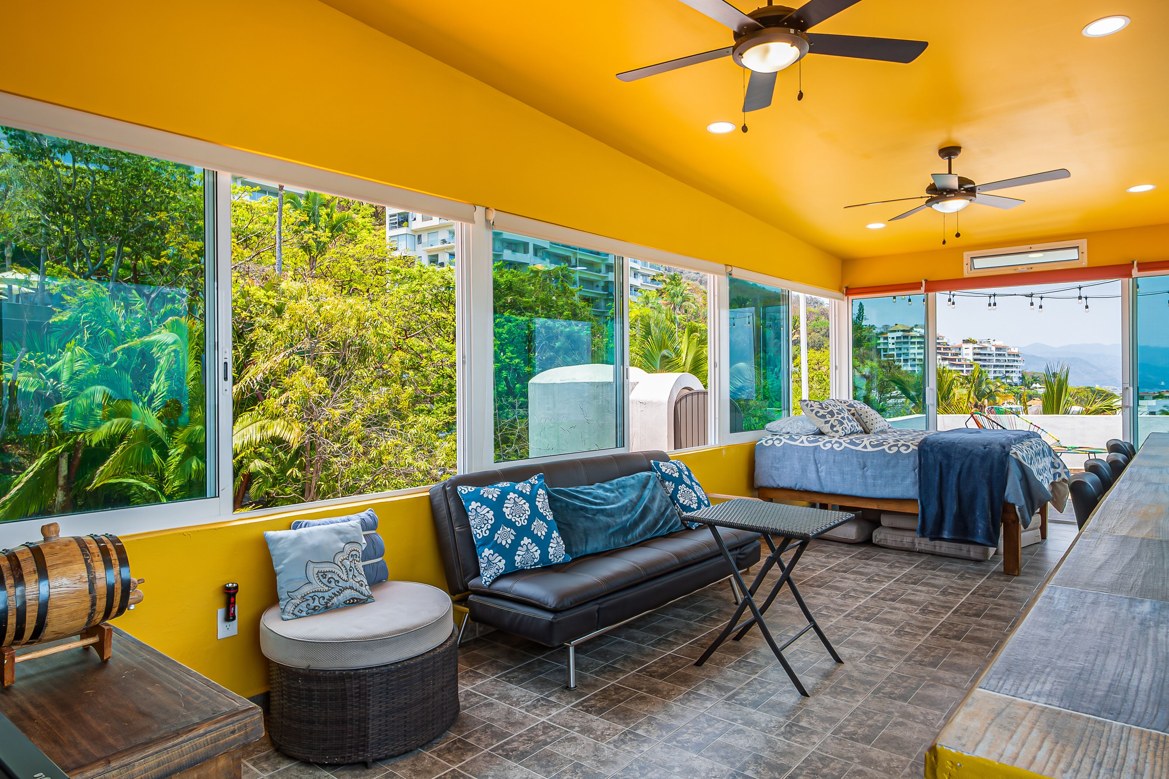 A room with a sofa, a small table, and a ceiling fan.