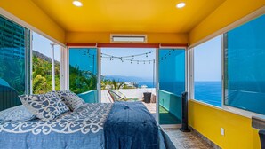 A bedroom with a bed, a balcony with a view, and a window. - Gardenias Studio Studio in Puerto Vallarta With Panoramic Views (Puerto Vallarta)