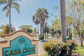 A sign for 'CASA CLUB' with a clear view of palm trees and a well-maintained garden. - Golf Course-adjacent Getaway With Infinity Pool, Private Plunge Pool & Balcony (Nuevo Nayarit)