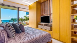 Een moderne slaapkamer met een groot bed, een televisie en uitzicht op zee.