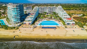 Een resort met meerdere gebouwen, een zwembad en een strand.