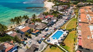 An aerial view of a coastal resort with a swimming pool, beach, and ocean. - Oceanfront Condo With Pool, Balcony, Amazing Views, Washer/dryer, & Partial AC (Punta de Mita)