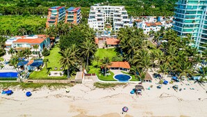 A resort with multiple buildings, a beach, palm trees, and a swimming pool. - Spacious Condo With Near the Beach With Resort-style Pool, Inviting Balcony (Nuevo Nayarit)