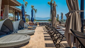 A rooftop pool area with lounge chairs, umbrellas, and a clear view of the mountains. - D'toscana Residencial, PH #2 Apartment in Nuevo Vallarta (Nuevo Nayarit)