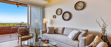A modern living room with a glass coffee table, a sofa, and a view of the city.