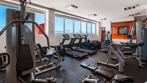 A gym with various exercise equipment, large windows, and a view of the mountains. - D'toscana Residencial, PH #2 Apartment in Nuevo Vallarta (Nuevo Nayarit)