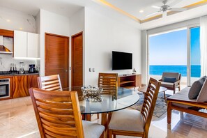 A modern kitchen with white cabinets, a wooden door, and a built-in oven. - 4th-floor Oceanfront Condo With Balcony, Outdoor Pool, Ocean Views & AC (Puerto Vallarta)