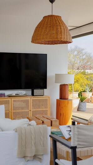 Ein modernes Wohnzimmer mit Fernseher, einer Korbtrophäe und einem Holznachttisch.