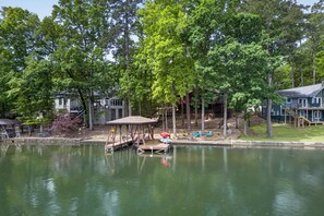 Una propietat a la vora d'un llac amb un moll, un porxo i un petit vaixell.