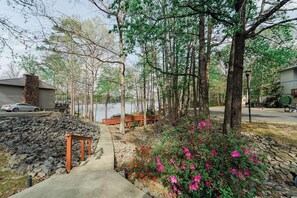 A residential area with a pathway, stone wall, and a bench.