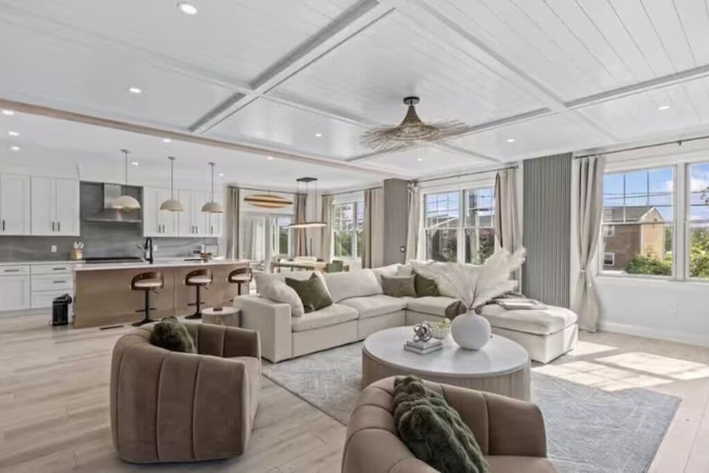 Uma sala de estar moderna com sofá, poltronas e mesa de centro.