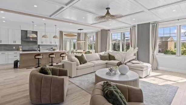 En moderne stue med sofa, lænestole og sofabord.