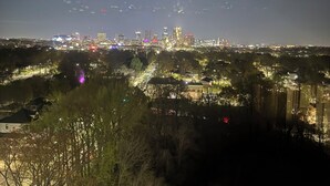 Une vue nocturne d’une ville, avec des bâtiments illuminés et une rivière.