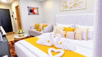 Una camera d'albergo con un letto grande, un comodino, una sedia e una sveglia a muro.
