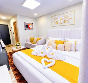 Une chambre d’hôtel avec un grand lit, une table de chevet, une chaise et une horloge fixée au mur.