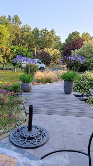 A paved pathway with potted plants and a decorative metal piece. - "L'oasis des pins" House 12 pers+ swimming pool 20mm from Le MANS (Château-l'Hermitage)