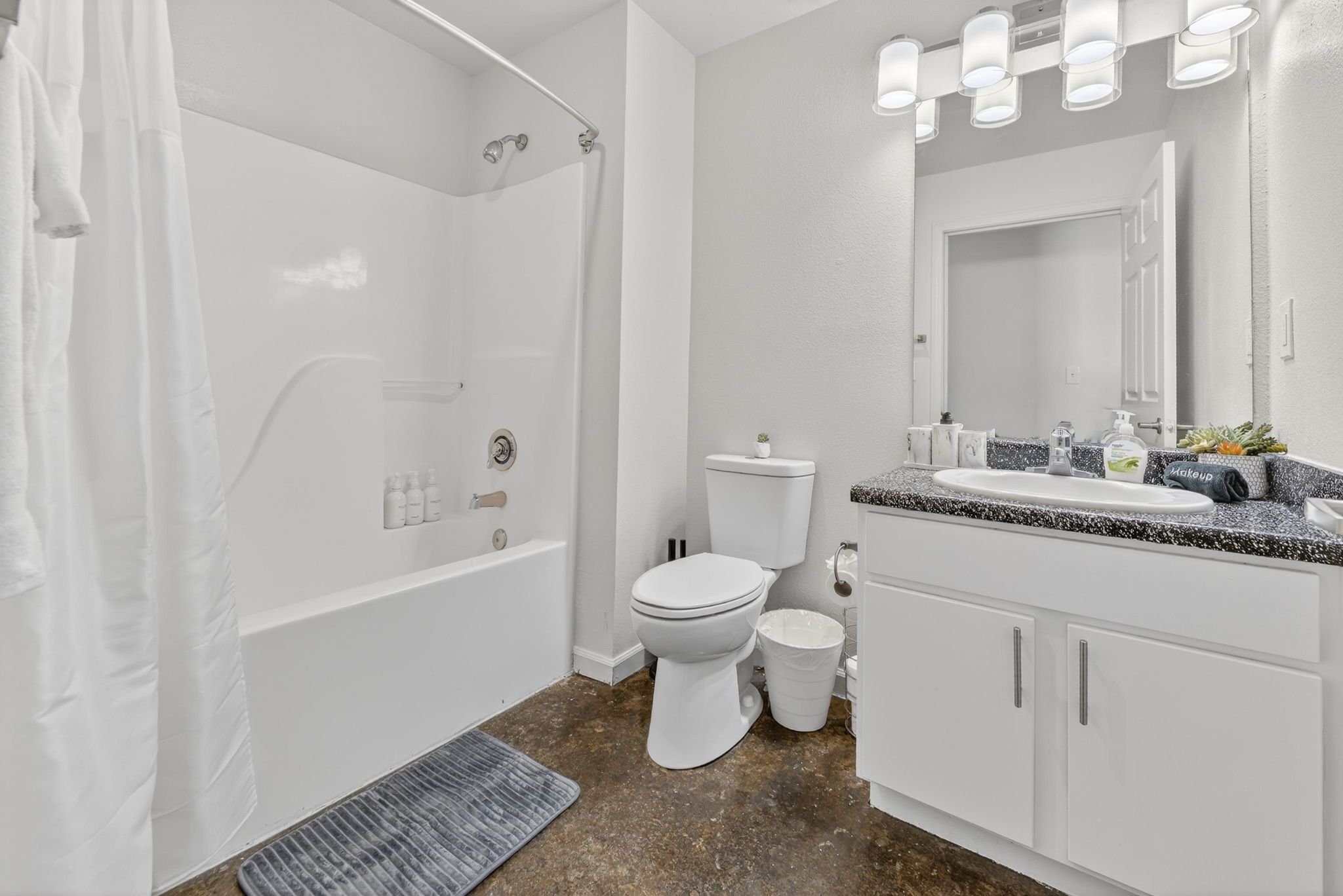 A bathroom with a bathtub, toilet, sink, and shower.