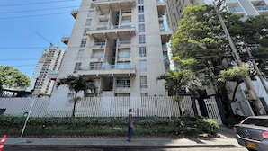 A multi-story residential building with balconies, a white fence, and a parked car. - Oceana Suites Cartagena de Indias (Cartagena)