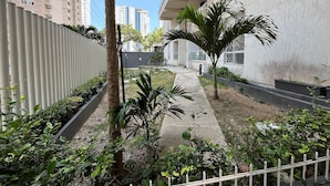 A courtyard with a pathway, palm trees, and a building with balconies. - Oceana Suites Cartagena de Indias (Cartagena)