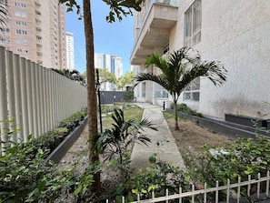 A courtyard with a pathway, palm trees, and a building with balconies. - Oceana Suites Cartagena de Indias (Cartagena)