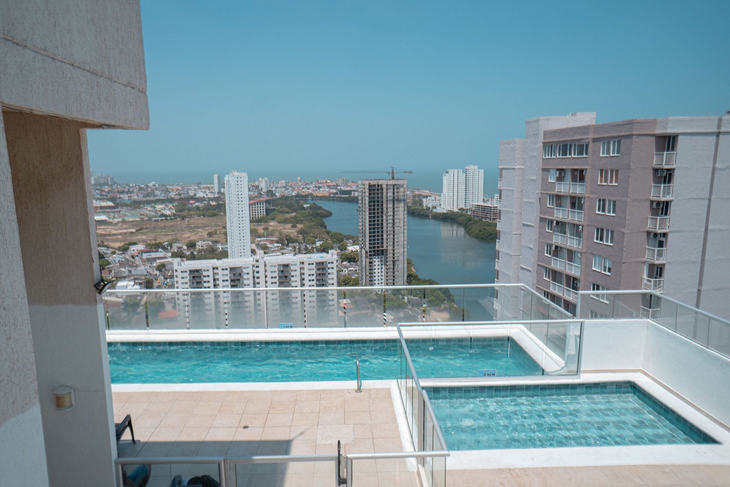 Une piscine sur le toit offrant une vue dégagée sur le paysage urbain et une rivière.