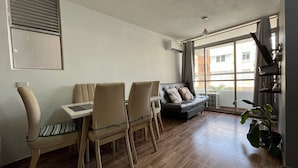 A living room with a sofa, chairs, a table, a large window, and a plant. - Oceana Suites Cartagena de Indias (Cartagena)