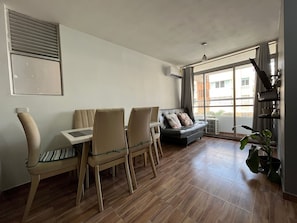 A living room with a sofa, chairs, a table, a large window, and a plant. - Oceana Suites Cartagena de Indias (Cartagena)