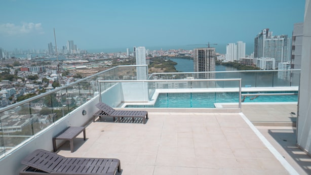 A rooftop pool with lounge chairs, a clear view of the cityscape, and a glass balustrade. - Oceana Suites Cartagena de Indias (Cartagena)