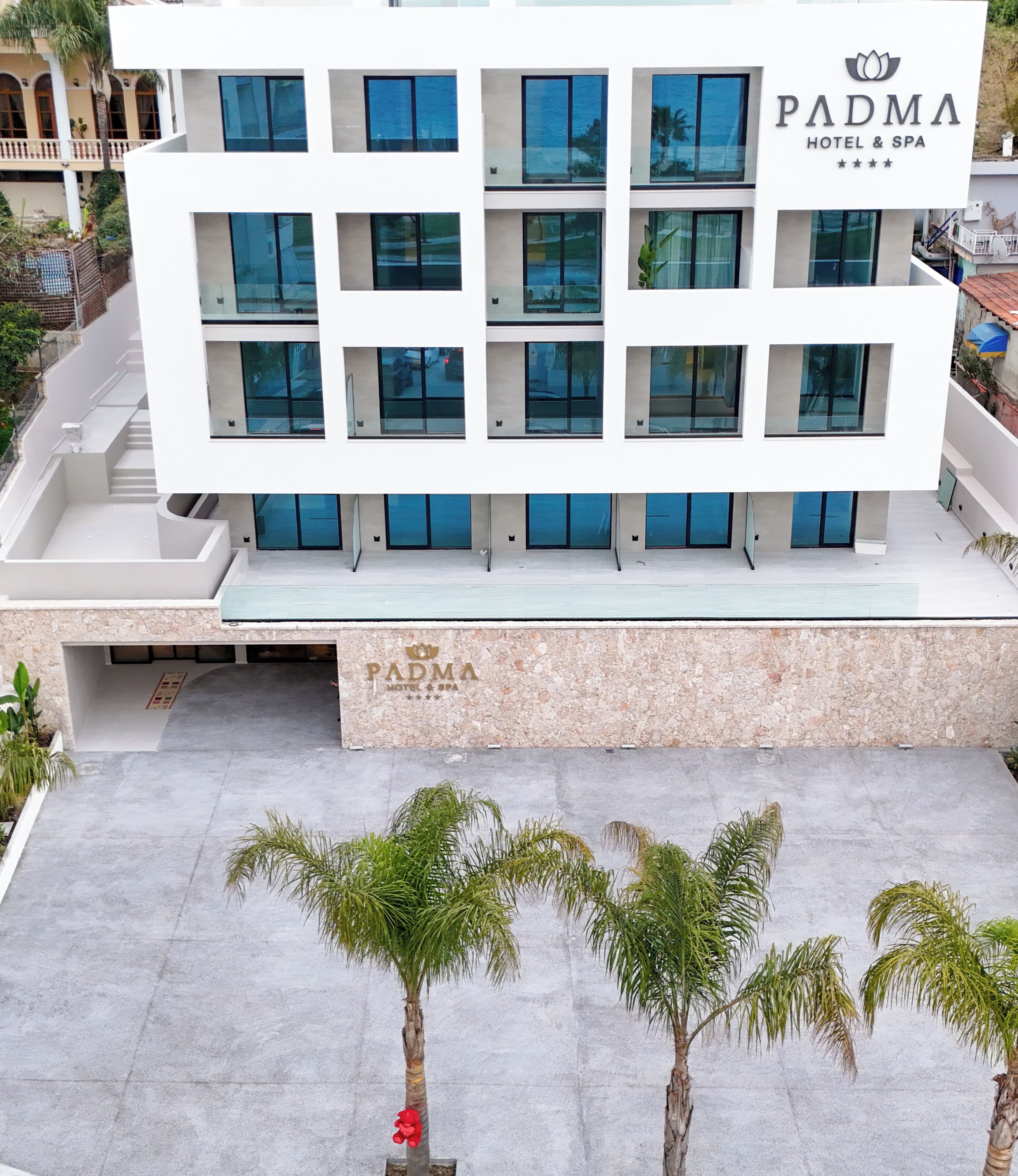 A modern hotel building with a flat roof, multiple windows, and a sign reading 'PADMA HOTEL & SPA'.