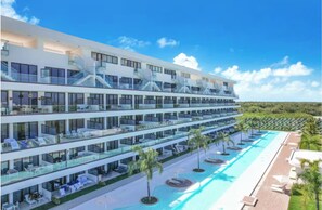 A multi-story hotel with balconies, a swimming pool, and a tropical landscape. - Penthouse Duplex w/ Large Terrace, Pool, Golf and Ocean Views (Punta Cana)