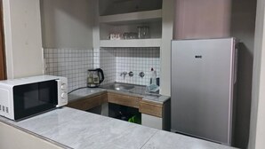 A compact kitchen with a microwave, kettle, sink, and refrigerator. - The Pot Faerie Glen in Pretoria (Pretoria)