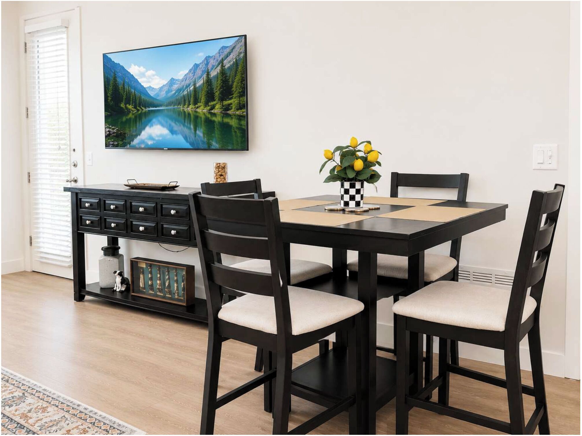 A dining area with a table, chairs, a television, and a vase with yellow flowers.
