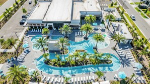 An aerial view of a hotel with a central swimming pool, lounge areas, and a parking lot. - Modern Getaway w/Game Room + Pvt Pool + BBQ Near Universal and I-Drive (Orlando)