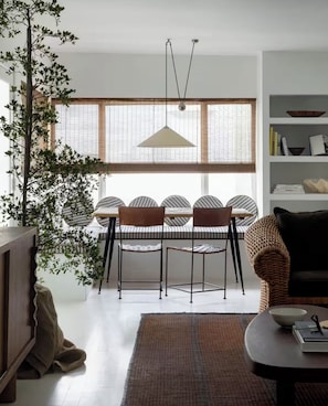 A dining area with a table and chairs, a hanging light fixture, and a large window with blinds. - 2 Bedroom Steps 2 Sand Oceanview Beach Retreat (Marina del Rey)