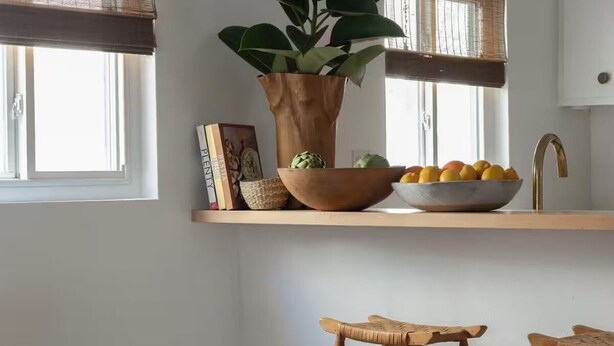 A kitchen with a wooden countertop, a potted plant, a bowl of fruit, and two wooden stools. - 2 Bedroom Steps 2 Sand Oceanview Beach Retreat (Marina del Rey)