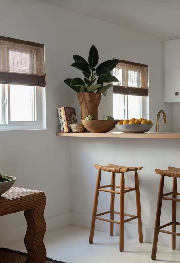 A kitchen with a wooden countertop, a potted plant, a bowl of fruit, and two wooden stools. - 2 Bedroom Steps 2 Sand Oceanview Beach Retreat (Marina del Rey)