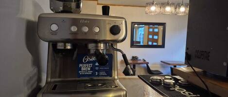 Una máquina de café espresso comercial con una etiqueta que dice 'Perfect Brew' en un ambiente de cafetería.