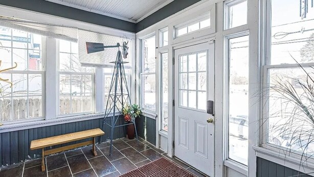 A room with a bench, a ladder, and a door.
