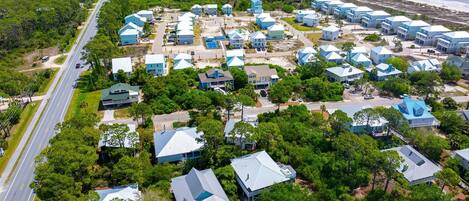 Vista aérea de una zona residencial costera con casas, una carretera y una playa.