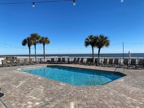 A rectangular pool with clear blue water, surrounded by a brick patio and lounge chairs. - New Listing! 105 Grand Pavilion - Remodeled! (Isle of Palms)