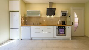 Cocina moderna equipada con refrigerador, microondas, horno y lavavajillas.