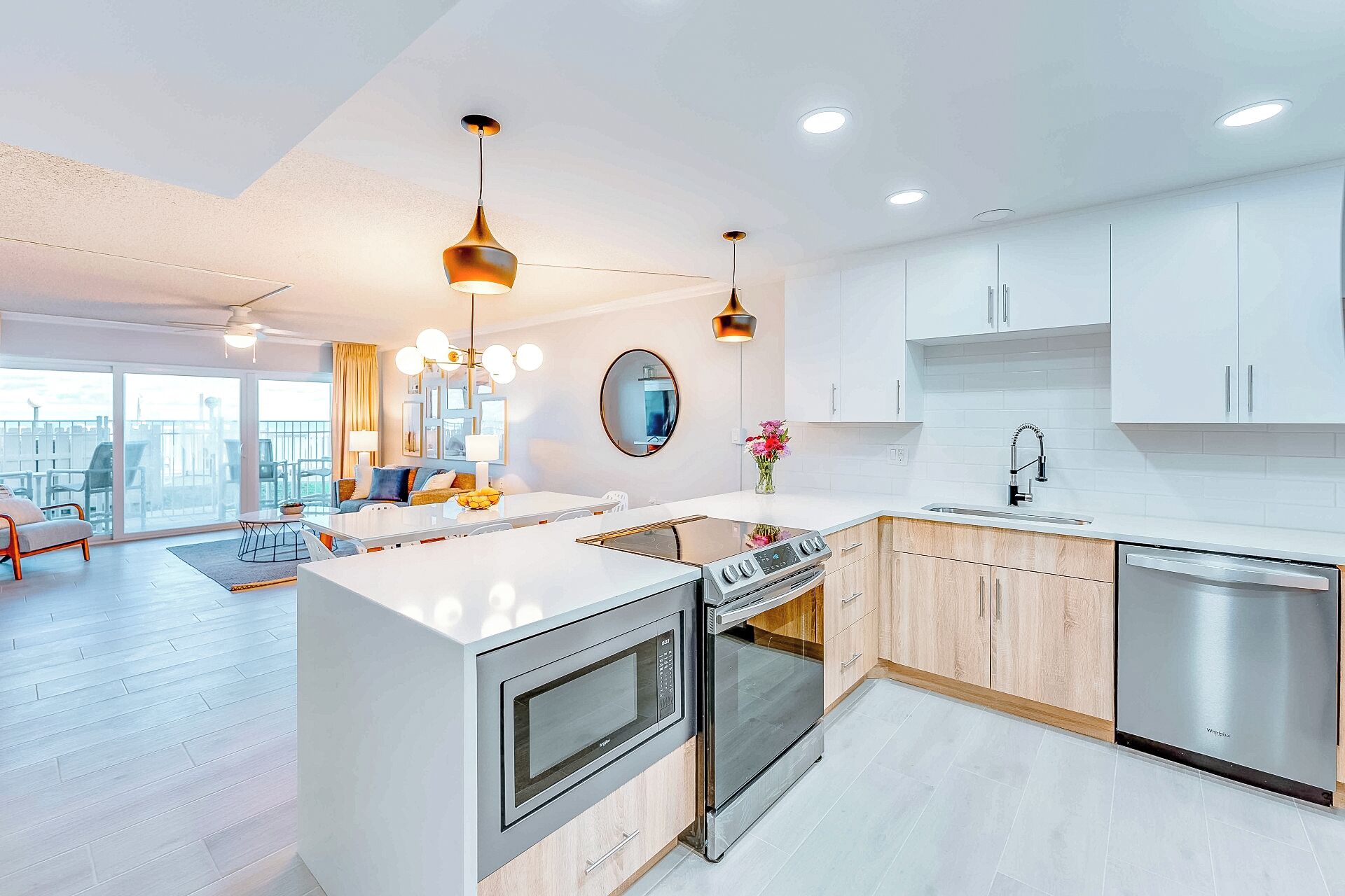 A modern kitchen with white cabinets, stainless steel appliances, and a central island.
