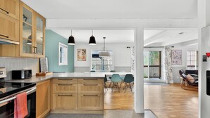 Una cucina moderna con mobili in legno, un'isola centrale e luci a sospensione.
