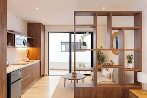 Eine moderne Küche mit Holzschränken, einem eingebauten Backofen und einem Essbereich mit rundem Tisch und einer Sitzecke.