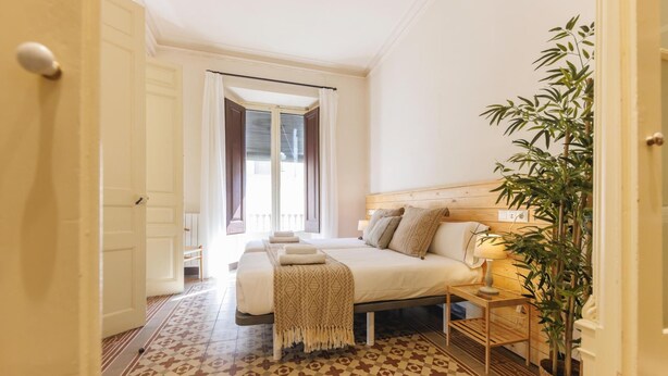 Ein Schlafzimmer mit Bett, Nachttisch, Lampe und einem Blumentopf.